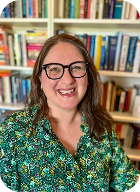 Smiling female rabbi with dark shoulder length hair and a green blouse