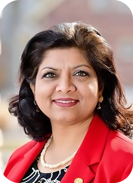 Woman smiling with dark brown hair and a red blazer