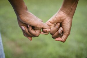 A close up of two hands clasping pinkies